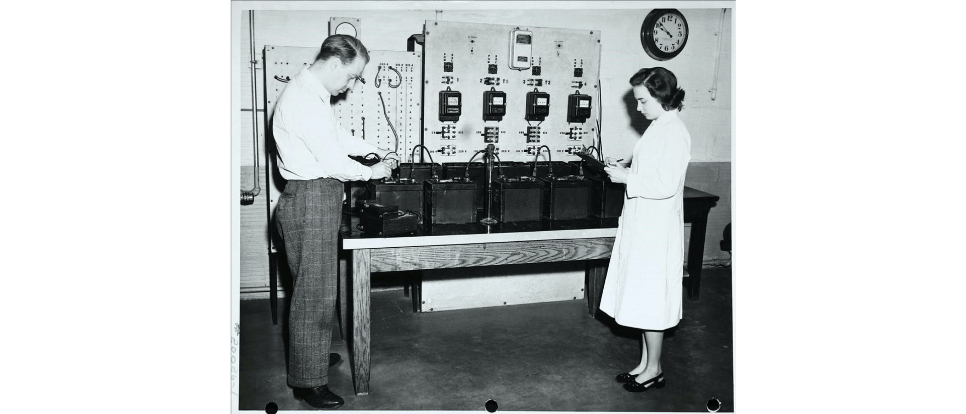 Two staff members study and test batteries additives.