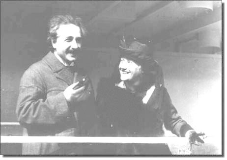 Archival black-and-white photo of a woman smiling at a man as he smiles into the distance.