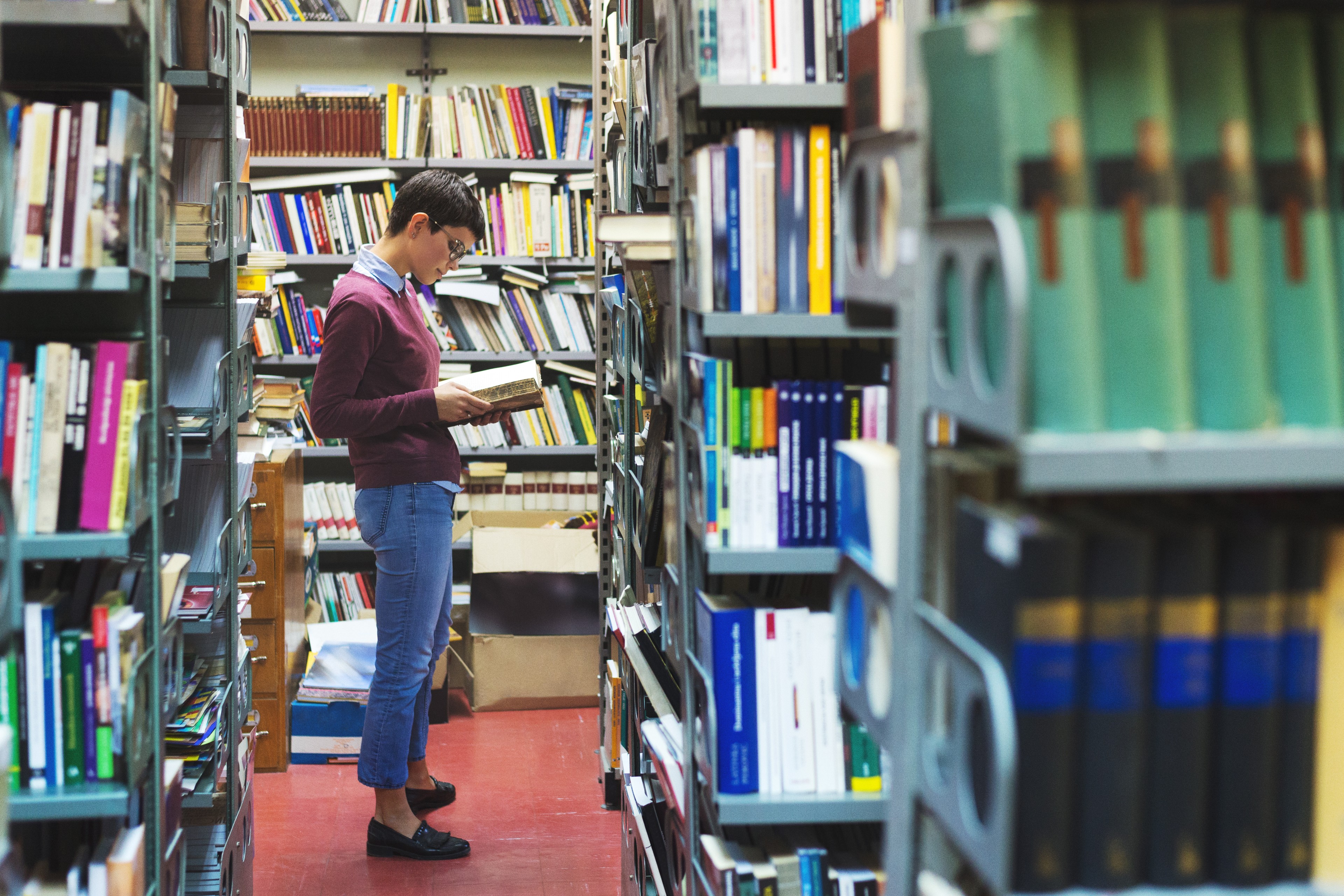 woman looking at a book in a library