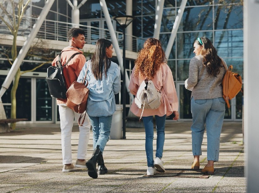 Four students walking together on a college campus