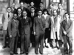 Group of physicists posing on the steps of LANL