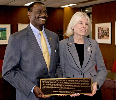Allen Sessoms President of UDC and Kate Kirby Executive Officer of APS holding the plaque