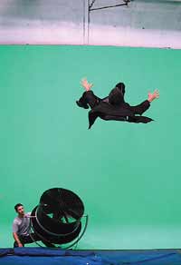 Attached to wires and blown by a wind machine, Briane Greene 'flies' through the air against a green screen background, replaced in the editing process by footage of a city street scene. Photo Credit: Andrea Cross for WGBH